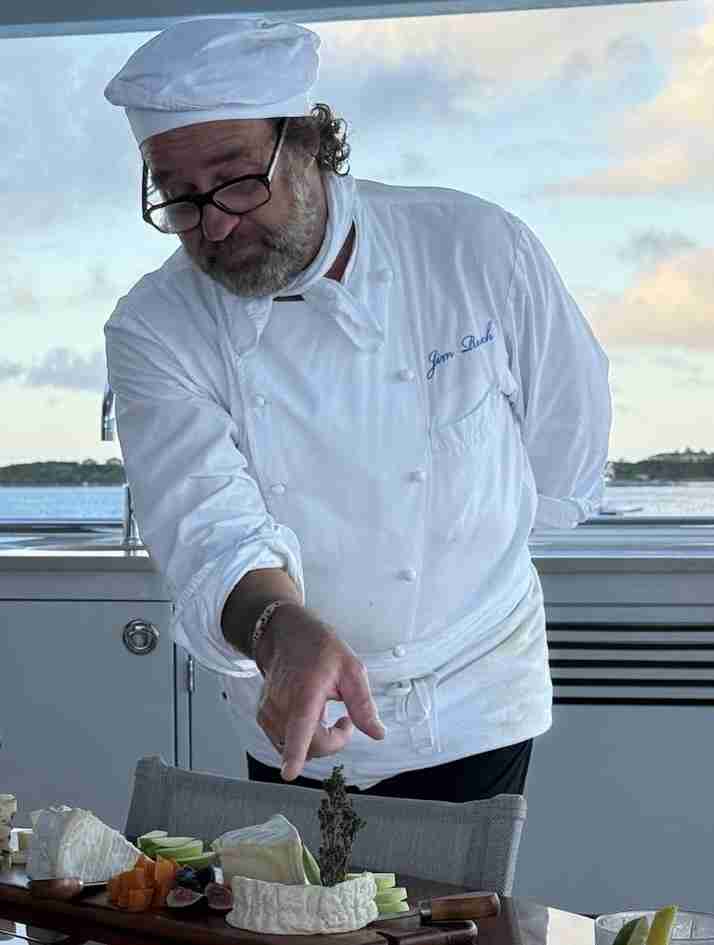Private yacht chef Jim Ruch Ruch in his natural environment. Describing various cheeses to distinguished guest. Caribbean and Bahamas yachting.